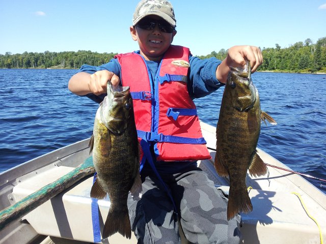 2012-08-29 12.07.29.jpg - Josh shows his continued success on Clear Lake – Arnstein with his 1st and 2nd Smallmouth Bass of the day – both released to give another angler the enjoyment he just had.